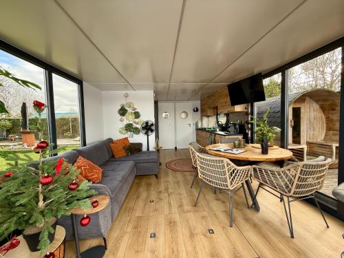 een woonkamer met een bank en een tafel bij NEW - Little Asia - Stunning Boathouse on a lake Near Amsterdam with Sauna in Vinkeveen