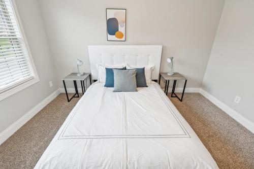 a white bed in a white room with two tables at Biltmore Luxury 1513 #2 Townhomes L 2bd 2 Bth in Clarksville