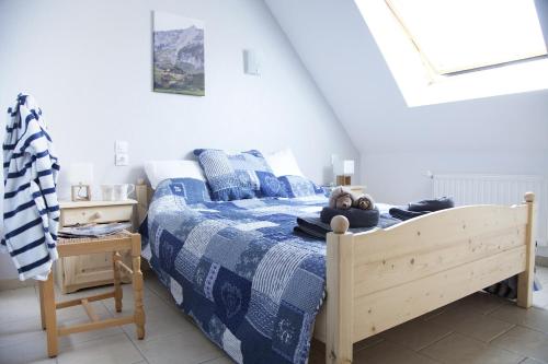 a bedroom with a bed with a blue and white comforter at Gîtes Estives d'Arrens in Arrens-Marsous