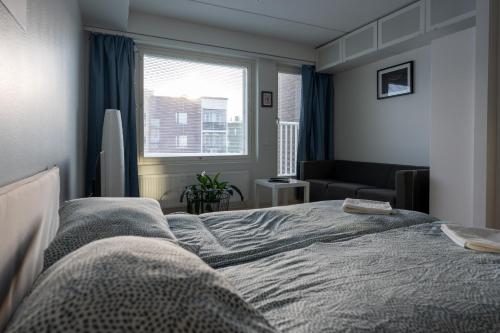 a bedroom with a bed and a window at Transit Apartments HEL Airport in Vantaa