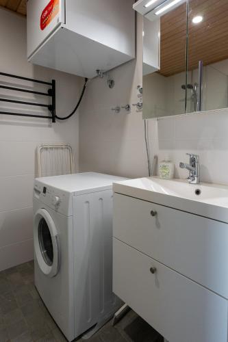 a white laundry room with a sink and a washing machine at Transit Apartments HEL Airport in Vantaa