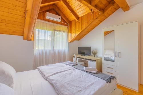 a bedroom with a bed and a desk with a computer at Villa Hills in Janja Gora