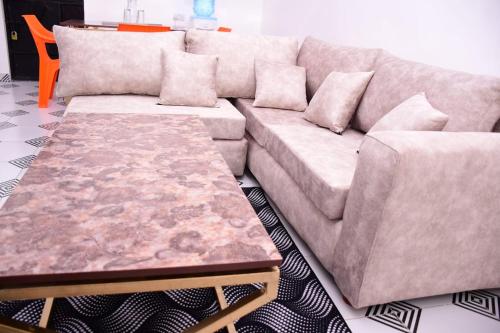 a couch and a coffee table in a living room at The White House apartments in Libwezi