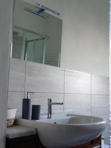 Un baño blanco con lavabo y espejo. en Carlotta House-LT, en Bellano