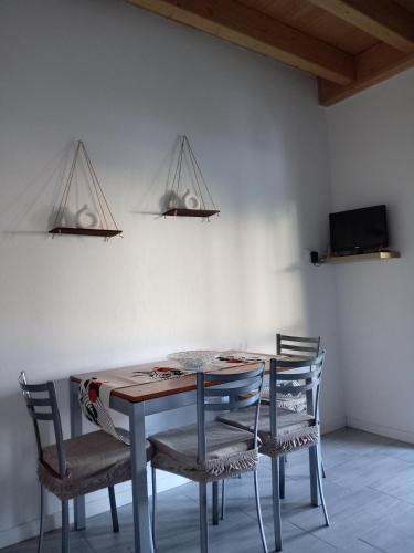 Una mesa de comedor con sillas y dos lámparas. en Carlotta House-LT, en Bellano