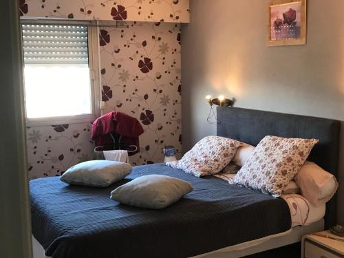 un lit avec des oreillers dessus dans une chambre dans l'établissement Le Pêcheur, à Cagnes-sur-Mer