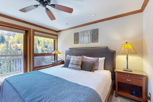a bedroom with a bed with a ceiling fan and a window at Lion Square Lodge South 650 in Vail
