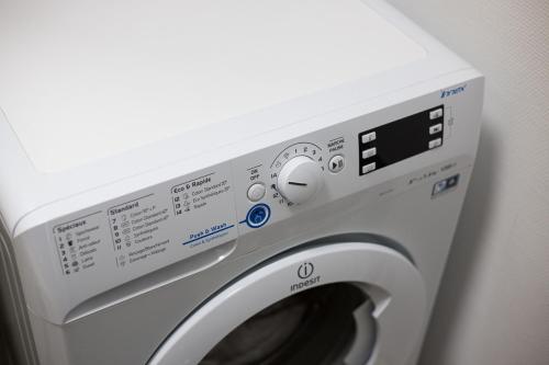 a white washing machine sitting next to a wall at Studio cosy et lumineux bike parking in Saverne