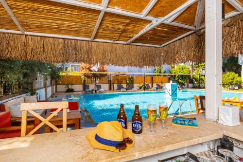 a table with drinks and a hat on it next to a swimming pool at Legend Of Dalyan Hotel in Dalyan