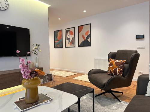 a living room with a couch and a chair at Aparte - Prishtina e re in Pristina