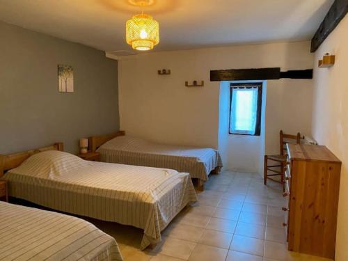 une chambre d'hôtel avec trois lits et une fenêtre dans l'établissement Gîte de 4 ou 5 personnes la Draille, à Gravières