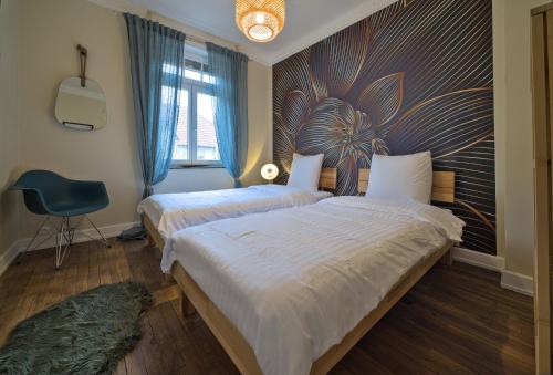 une chambre avec deux lits et une chaise et une fenêtre dans l'établissement UnSejourAMetz - Cheverny, 5 min gare, 3 chambres, à Metz