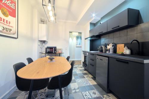 une cuisine avec une table en bois et quelques chaises dans l'établissement UnSejourAMetz - Cheverny, 5 min gare, 3 chambres, à Metz