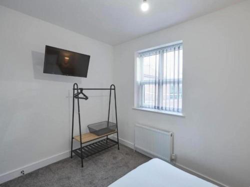 a room with a tv on the wall and a shelf at Zetland House Apartment 3 Loftus in Loftus