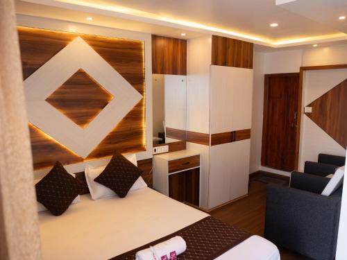 SuryodayaにあるHotel DARPAN PALACEのベッドと椅子のあるホテルの部屋