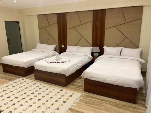 two beds in a room with white sheets at Giza Palace Pyramids View in Cairo