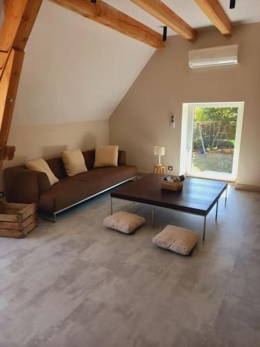 un salon avec un canapé et une table dans l'établissement La grange de Baffol, à Saint-Chamarand