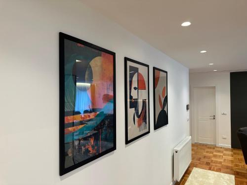 a group of framed art on a white wall at Aparte - Prishtina e re in Pristina