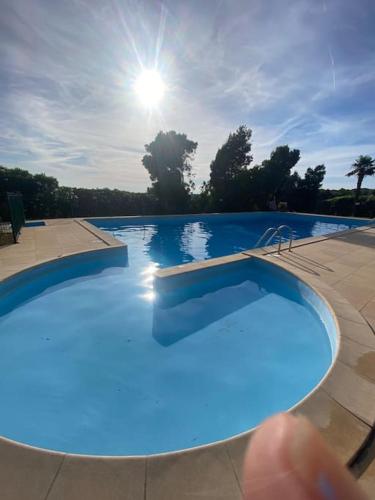 une personne pointe du doigt une piscine bleue dans l'établissement Maison mer piscine Cargese à 1 heure d'Ajaccio, à Cargèse