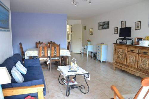 a living room with a blue couch and a table at Appartement centre d'Arcachon à 400 m de la plage in Arcachon