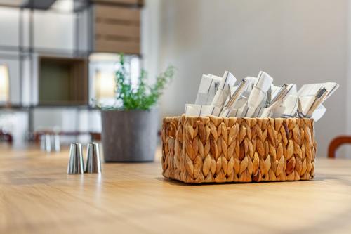 Una cesta de cuchillos encima de una mesa. en IntercityHotel Dortmund, en Dortmund