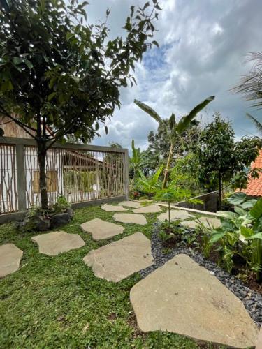 a garden with stepping stones in the grass at Purwa Ijen in Banyuwangi