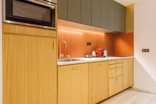 une cuisine avec des armoires en bois et un évier dans l'établissement Charming duplex - 2BR - 6P - Saint Germain, à Paris