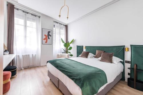 une chambre avec un grand lit avec une tête de lit verte dans l'établissement Charming duplex - 2BR - 6P - Saint Germain, à Paris