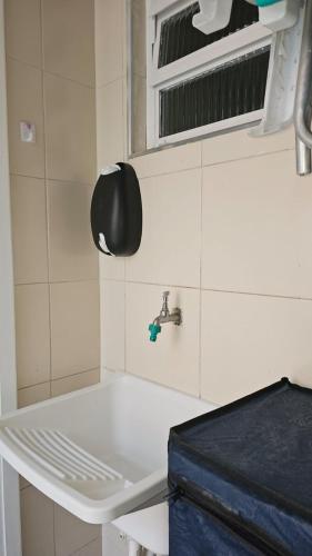 a bathroom with a white sink and a faucet at Casinha de Boneca em Juquey in Juquei
