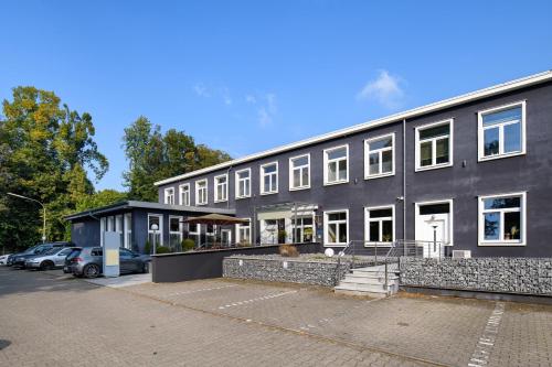 a black building with cars parked in a parking lot at SleepinRoomz Boutique Hotel in Dortmund