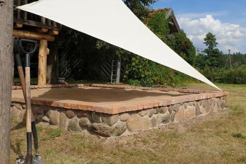 a white umbrella sitting on top of a stone wall at Pasieka i Dom Mazurski Mącze in Mącze