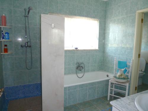 baño con bañera y ducha con ventana en Highview Villa, en Lagos