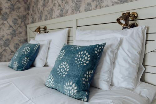 a bed with white pillows and blue and white pillows at Bauergården in Gränna