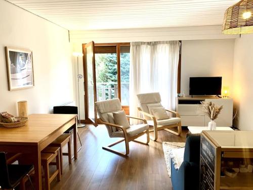 a living room with a table and chairs and a television at Appartement au pied des pistes et du telemix in Les Deux Alpes