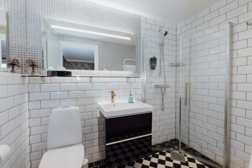 a white bathroom with a sink and a mirror at Bauergården in Gränna