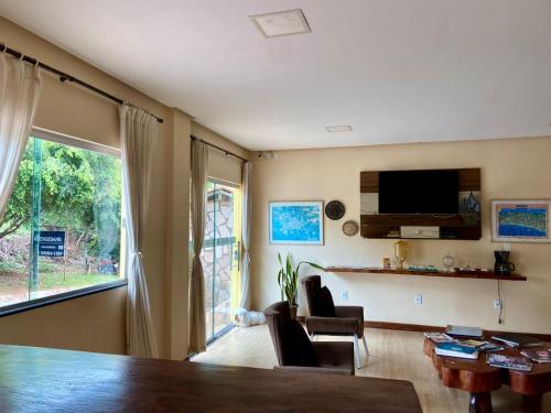 a living room with a television and a table and chairs at Pousada das Arvores in Lençóis