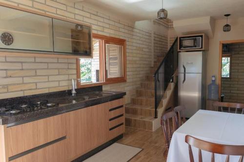una cocina con encimera y refrigerador en Morada Paraíso dos Canyons, en Praia Grande