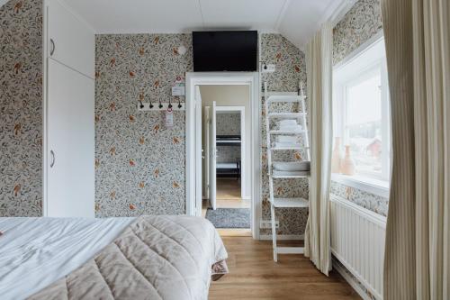 a bedroom with a bed and a staircase and a window at Bauergården in Gränna
