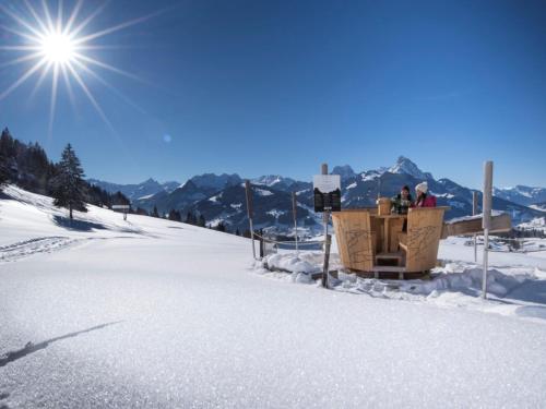 two people sitting in a ski lift in the snow at Hotel Kernen in Gstaad