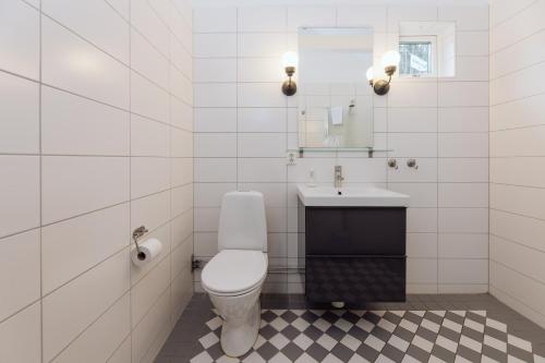 a white bathroom with a toilet and a sink at Bauergården in Gränna