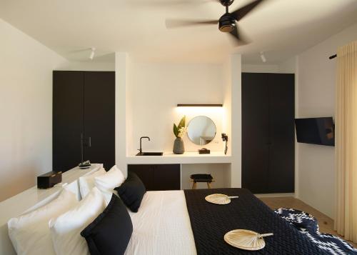 a bedroom with a bed with a ceiling fan and a mirror at Absolute Paradise Santorini in Akrotiri