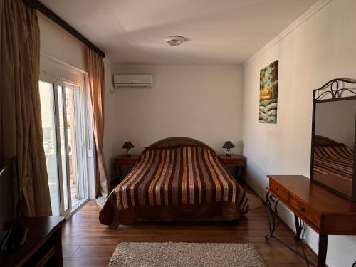a bedroom with a bed and a dresser and a window at Villa del Mare in Dobra Voda