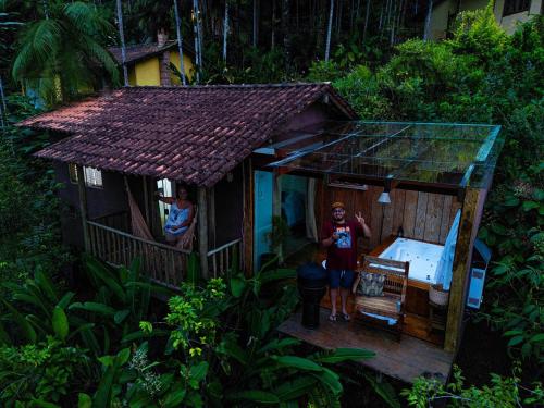 a man standing outside of a small house at Chalés Paraty Real in Paraty