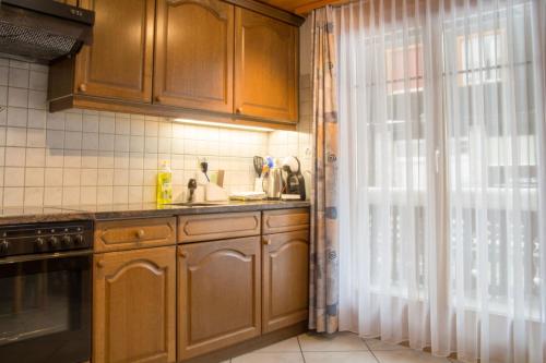 a kitchen with wooden cabinets and a sink and a window at Chalet Wurzenbord 1 in Bettmeralp