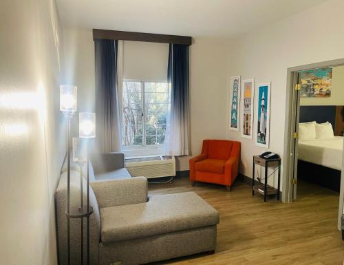 a living room with a bed and a chair and a window at La Quinta by Wyndham Birmingham Homewood in Birmingham