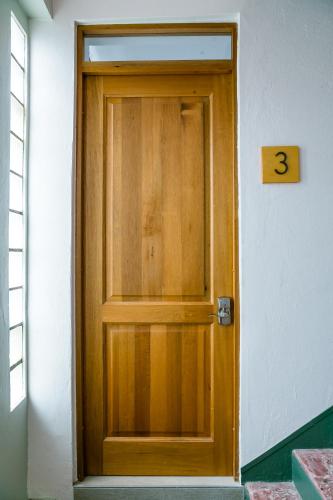 a wooden door with the number three on it at N1 Condos in San Juan