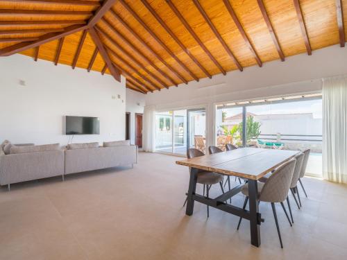a dining room with a wooden table and chairs at VILLA LOBOS with private pool and BBQ in Caleta De Fuste