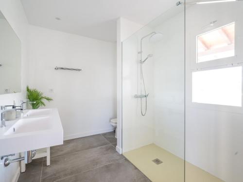 a white bathroom with a shower and a sink at VILLA LOBOS with private pool and BBQ in Caleta De Fuste