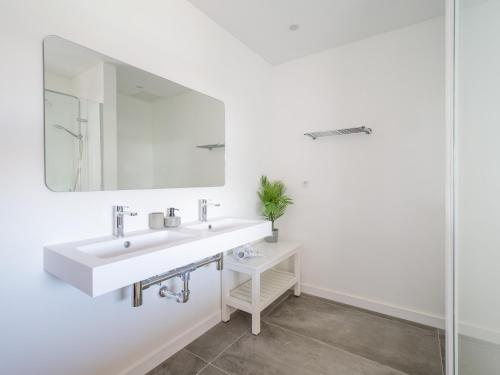 a white bathroom with a sink and a mirror at VILLA LOBOS with private pool and BBQ in Caleta De Fuste
