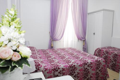 a bedroom with a bed and a table with flowers at Albergo Casablanca in Naples
